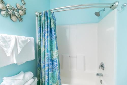 a bathroom with a shower with a shower curtain at Barefoot Resort - Cypress Bend 123 - Windy Hill in North Myrtle Beach