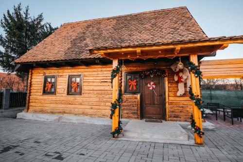 Little Bear Lodge في سيبيو: كابينة خشبية مع ديكورات عيد الميلاد على الباب
