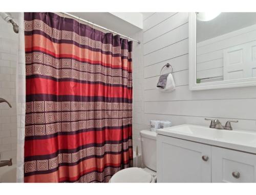 a bathroom with a shower curtain and a sink at Housepitality - The Franklinton Crown - Location in Columbus