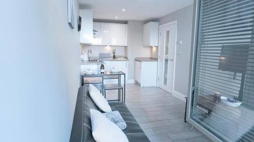 a living room with a couch and a kitchen at City Centre Seaview Apartment in Brighton & Hove