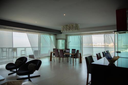 a dining room and living room with a view of the ocean at Luxury Condo Peninsula in Puerto Vallarta