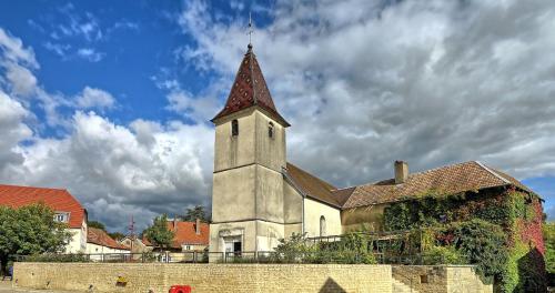 une église avec une cloche au-dessus d'un bâtiment dans l'établissement Tiny House - Home-One, à Dannemarie-sur-Crête