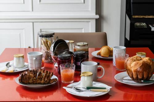 - une table avec des assiettes de nourriture, des boissons et du pain dans l'établissement Appartement Cuneta - Welkeys, à Paris