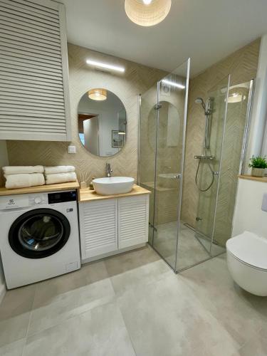 a bathroom with a washing machine and a sink at Cozy House in Świnoujście