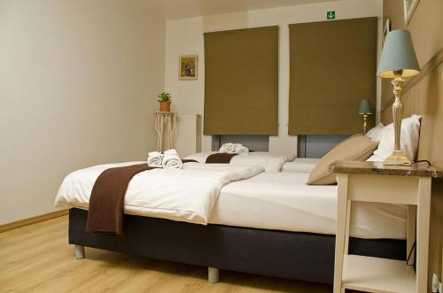 a bedroom with a large bed with white sheets at Hotel Apartments Belgium 1 - HAB 1 in Geel