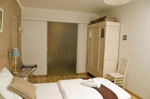 a bedroom with a bed and a cabinet and a chair at Hotel Apartments Belgium 1 - HAB 1 in Geel