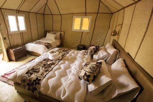 a bedroom with two beds in a room with a dome at Hamada Activities Luxury Camp in Merzouga