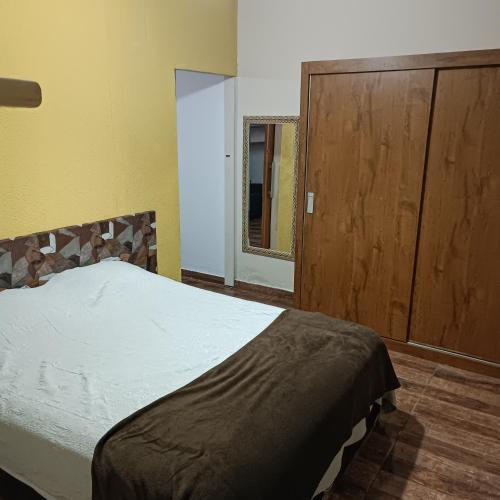 una camera da letto con un letto e un armadio in legno di casa de 1 Dorm prox Unesp Botucatu a Botucatu