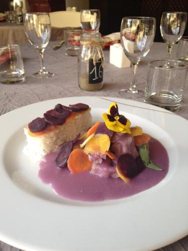 a white plate with a piece of food on a table at Logis Hotel la Ferme in Avignon