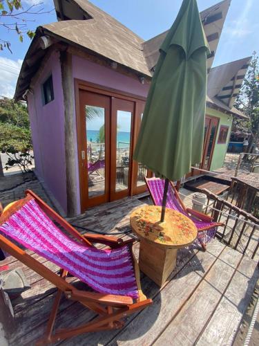 a patio with a table and a green umbrella at Bahía uvas Bungalos in Banco Playa