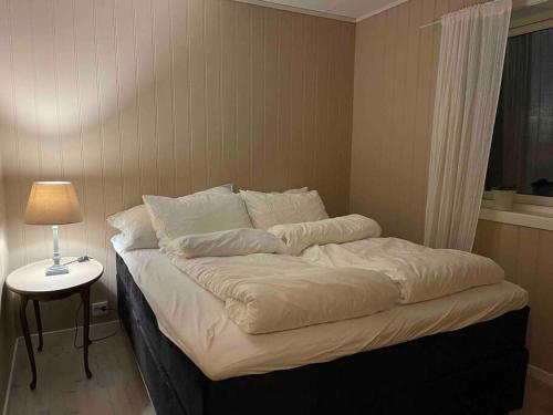 1 cama en una habitación con una lámpara en una mesa en Island life! 2,5 bedroom house. en Vigra