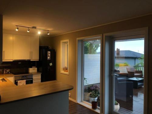 a kitchen with a large sliding glass door to a balcony at Island life! 2,5 bedroom house. in Vigra