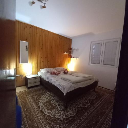 a bedroom with a bed and a wooden wall at Zlatarski Pogled in Nova Varoš