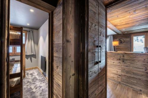 a room with a wooden wall and a bunk bed at Residence - Pièces 134 in Courchevel