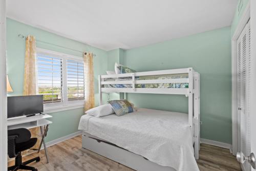 a bedroom with a bunk bed and a desk at Ocean Creek Resort E8 -Oceanfront - Windy Hill in Myrtle Beach