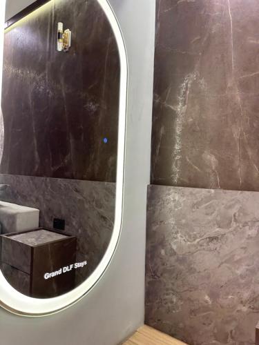 a bathroom with a mirror and a sink at Grand DLF Stays in Lucknow