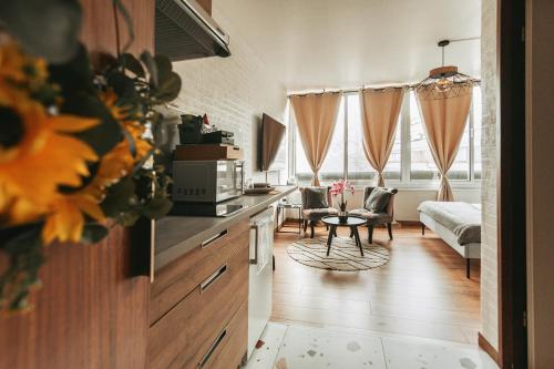 une cuisine et un salon avec un canapé et une table dans l'établissement Studio côté nature - trois épis de Turckheim, à Turckheim