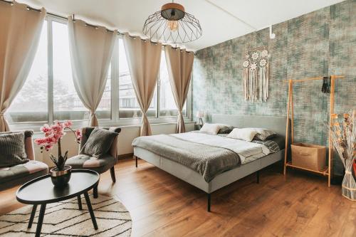 a bedroom with a bed and a couch and a table at Studio côté nature - trois épis de Turckheim in Turckheim