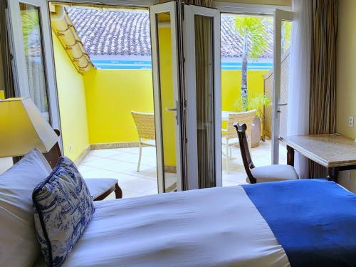 a bedroom with a bed and a balcony at Hotel Casa do Amarelindo in Salvador