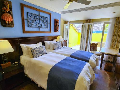 a bedroom with a large bed with blue walls at Hotel Casa do Amarelindo in Salvador