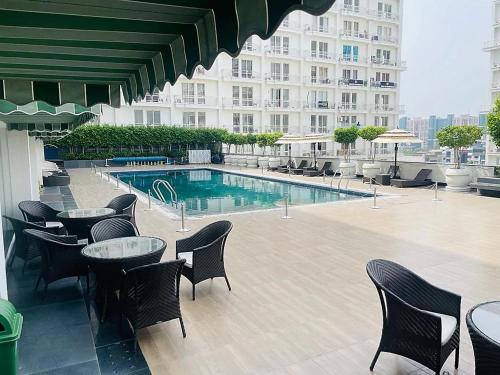 um pátio do hotel com mesas e cadeiras e uma piscina em Grand DLF Stays em Lucknow