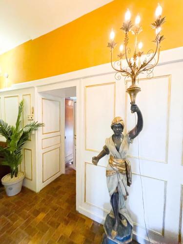 une statue d'une femme tenant une lumière sur un mur dans l'établissement Chateau Bourgeoisie ***, à Laimont