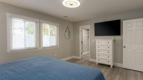 a bedroom with a bed and a flat screen tv at Bow Wow Bungalow - 3rd Row - Ocean Drive Section in Myrtle Beach