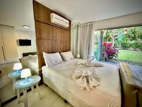 - une chambre avec 2 lits et une fenêtre dans l'établissement Bangalô Villas do pratagy com jacuzzi c, à Maceió