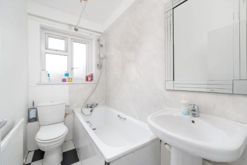 a white bathroom with a toilet and a sink at Spacious 1 Bed Flat in Dalston in London