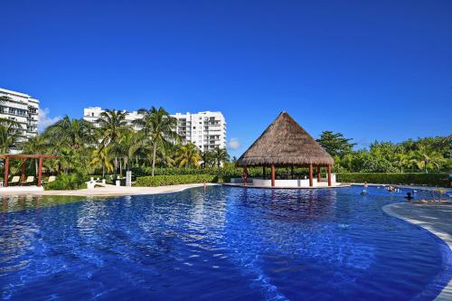 a large swimming pool with a gazebo in a resort at Beachfront apartment Blue Vista in Cancún