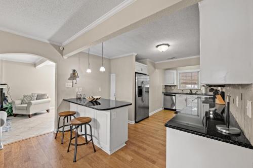 an open kitchen and living room with a counter and stools at Beaching On The Dunes - 3rd Row - Windy Hill Section in Myrtle Beach