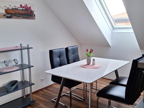 a dining room with a white table and black chairs at Apartment Martin in Merkendorf