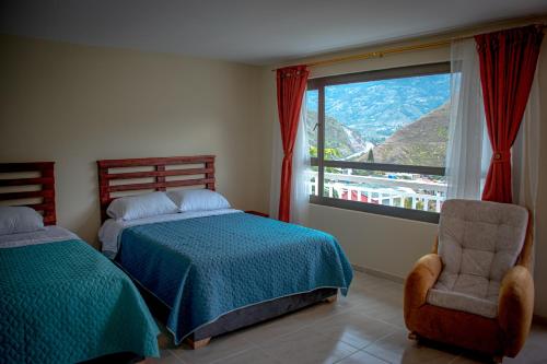 um quarto com 2 camas, uma cadeira e uma janela em Guayacan Hotel - Pedregal Rio 