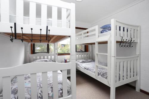 two white bunk beds in a white room at LingaLonga in Hawks Nest