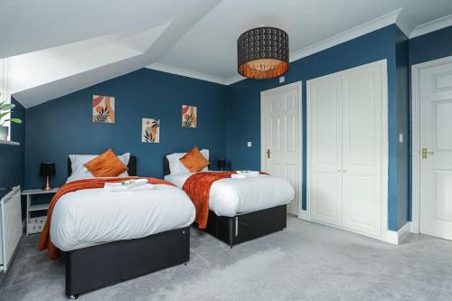 Serene Escape, Perfect Location in Canterbury Free Parking في Chartham: سريرين في غرفة بجدران زرقاء