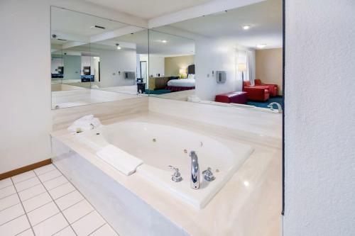 una grande vasca da bagno bianca in una stanza di Alliance Hotel and Suites ad Alliance