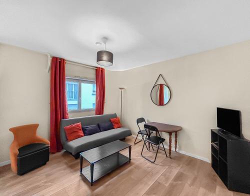 uma sala de estar com um sofá e uma mesa em Charme Citadin Angevin - hyper centre Angers em Angers