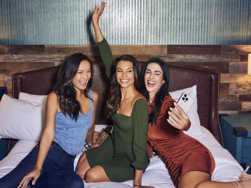 un grupo de tres mujeres sentadas en una cama en Silverton Casino Lodge - Newly Renovated, en Las Vegas