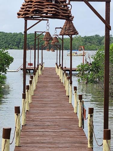 a wooden bridge over a body of water at Flow Guest House in Salinópolis