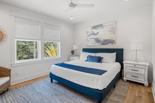 Un dormitorio con una cama grande y dos ventanas. en Shore Thing, en Santa Rosa Beach