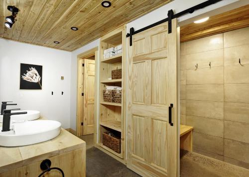 a bathroom with a wooden door and a sink at 25 Chemin Bonair in Stoneham