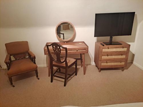 a bedroom with a desk and a chair and a mirror at Lapley Manor Lodge in Gailey