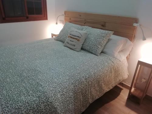 Un dormitorio con una cama con almohadas. en Carmencita y Manolito en Telde