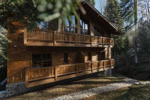 une grande maison en bois avec une grande terrasse dans l'établissement Chalet Royal, à Sinaia