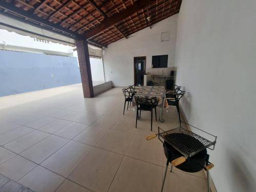 a large room with a table and chairs in it at Casa nova e confortável próxima ao Santuário in Aparecida