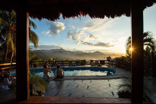 a group of people sitting around a swimming pool at Carlo's swimming pool in Rurrenabaque