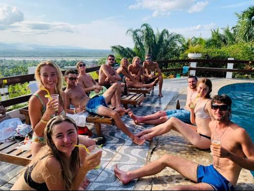un grupo de personas sentadas alrededor de una piscina con bebidas en Carlo's swimming pool, en Rurrenabaque