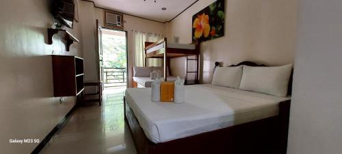 a hotel room with two beds and a window at Devayn's Inn in El Nido
