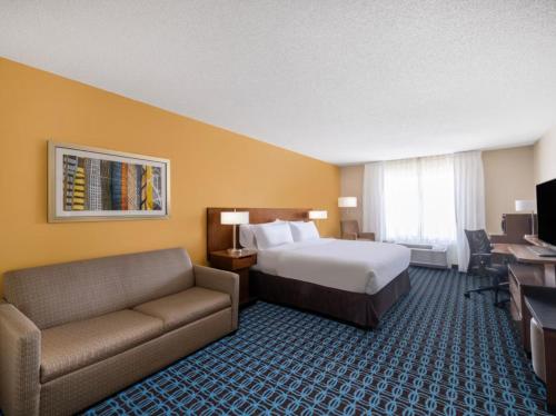 um quarto de hotel com uma cama e um sofá em Garner Hotel Macon West, an IHG Hotel em Macon