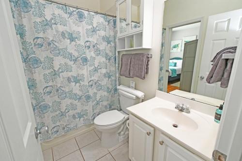 een badkamer met een toilet, een wastafel en een spiegel bij Sandpiper Cove Unit 4206 in Destin